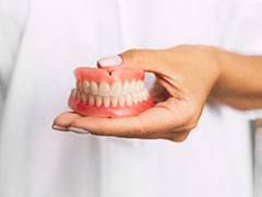 person holding removable dentures