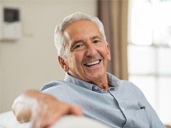 happy elderly man sitting on a couch