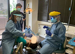 Dentist and dental team members safely treating patient