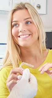 Young woman holding Invisalign tray