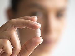 Hand holding a tablet antibiotic therapy pill