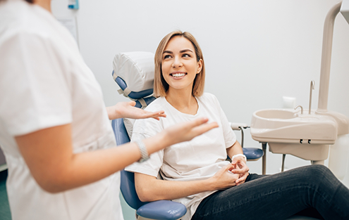 Woman in dental chair listening to her dentist