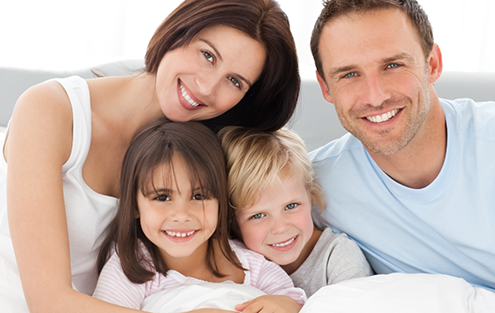 Family of four smiling after using Aetna dental insurance in Torrance