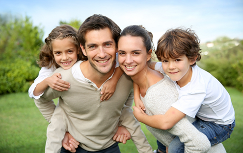 Family of four smiling in field