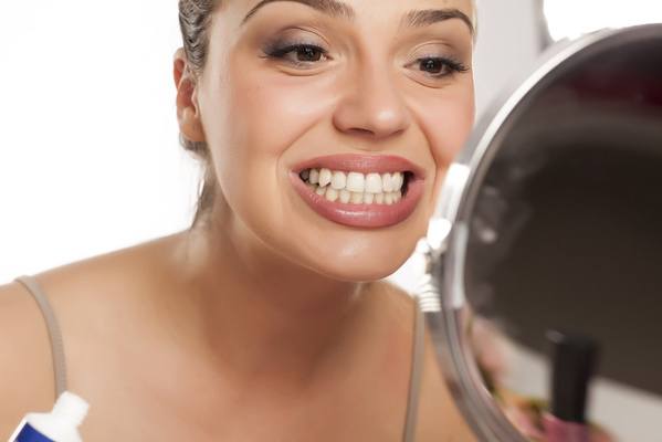 woman smiling into a mirror