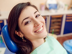 Smiling woman in dental chair after dental bonding
