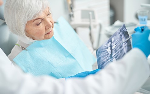 a dentist and patient examining an X-ray 