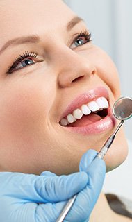 Smiling woman during preventive dentistry exam