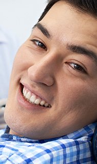 Smiling man in dental chair for emergency dentistry visit