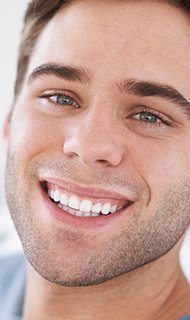 Young man with healthy attractive smile after gum tissue grafting