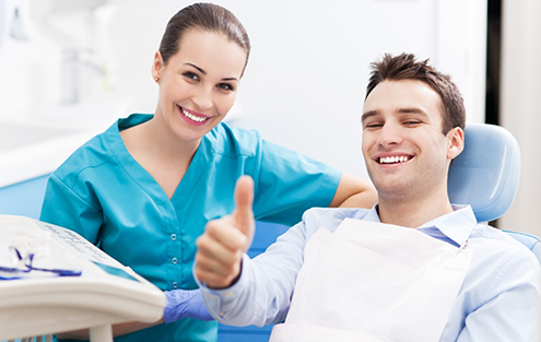 Man giving thumbs up in dental chair