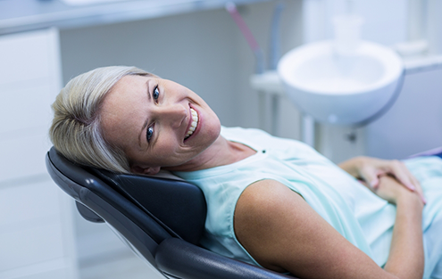 Smiling woman laying back in dental chair