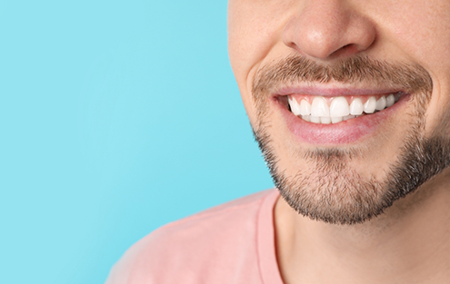 Man smiling against light blue background