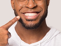 Man pointing to smile with veneers in Torrance