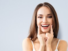 Woman pointing to smile after Invisalign