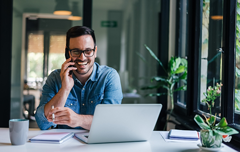 Man smiling while talking on phone