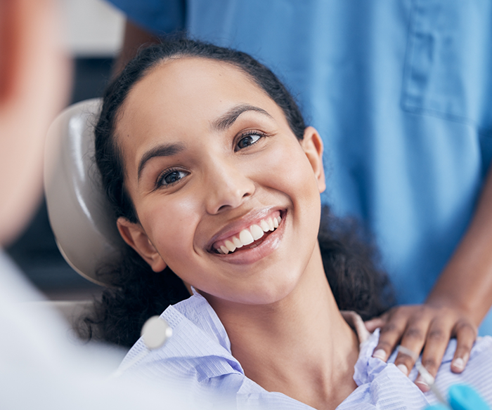 Woman in dental chair grinning after dental bonding in Torrance
