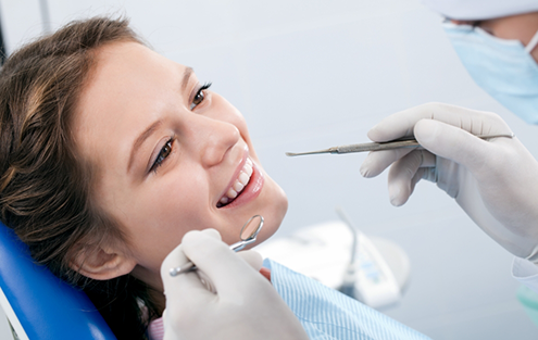 Woman in dental chair smiling at her dentist