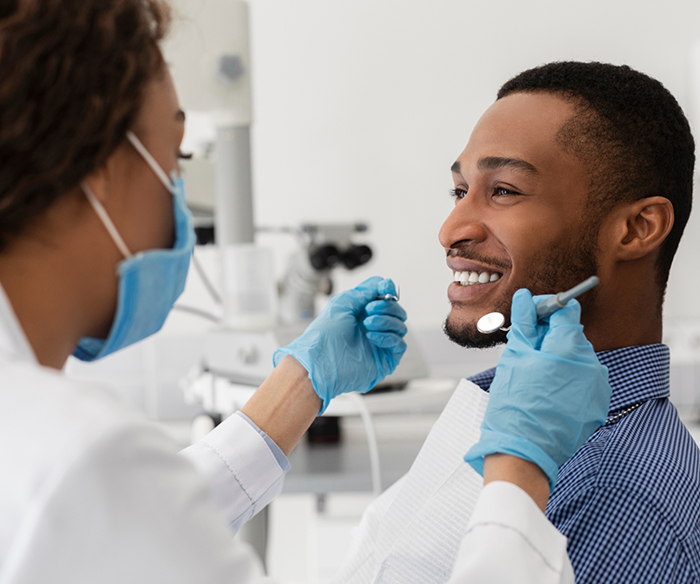 Man smiling at his dentist during a dental checkup and teeth cleaning in Torrance