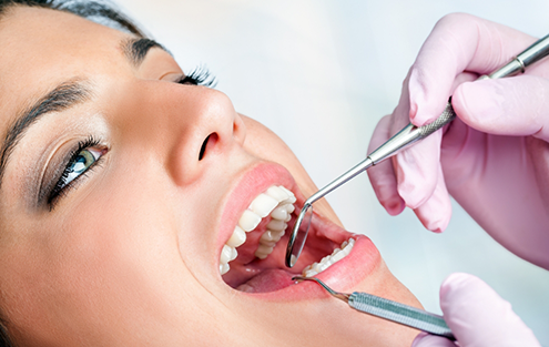 Woman getting her teeth cleaned by a dental hygienist