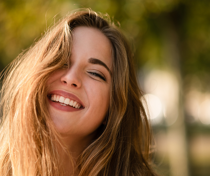 Young brunette woman smiling with dental crowns in Torrance