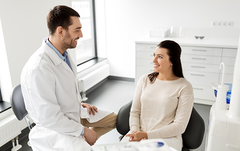 Woman in dental chair listening to her dentist