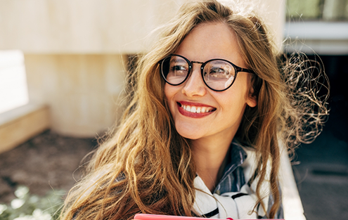 Woman with long hair and glasses smiling