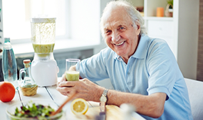 Older man drinking a green smoothie