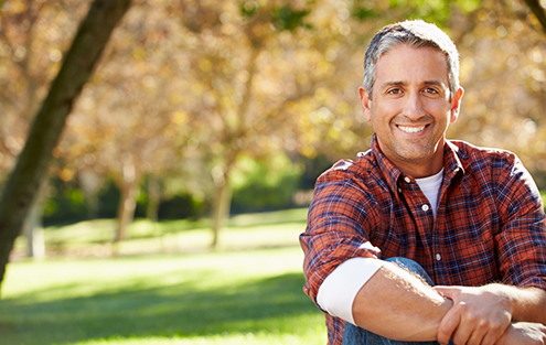 Man in red plaid shirt smiling outdoors