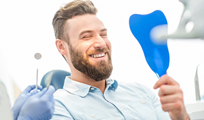 Bearded man admiring his smile in a mirror