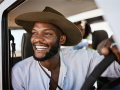 a person smiling and looking out a car window 