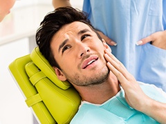 Man with toothache holding cheek