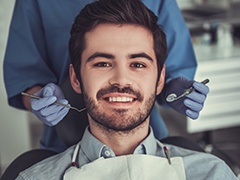 Smiling young man in dental chair after tooth colored filling placement