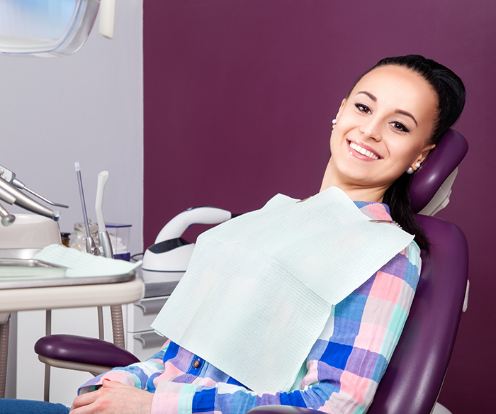 Woman smiling in dental chair after receiving fluoride treatment in Torrance