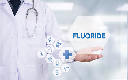 Outstretched hand and a graphic of the word fluoride