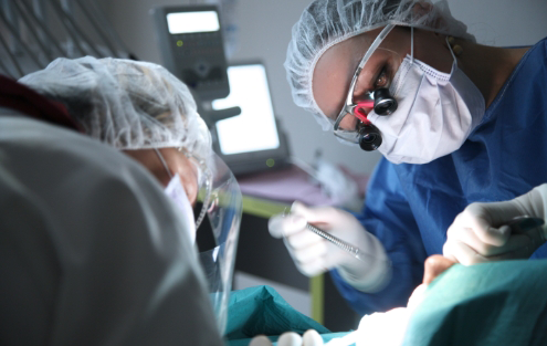 Dentist and assistant performing gum disease treatment on a patient