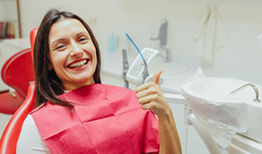 Smiling woman giving a thumbs up in the dental chair