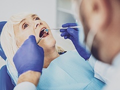An older woman undergoing a regular dental checkup after receiving dental implants in Torrance