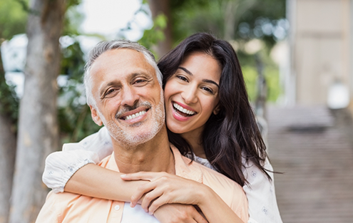 Couple hugging and smiling outdoors