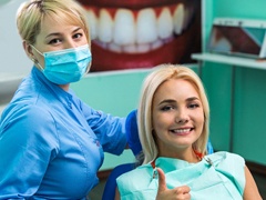 Patient giving thumbs up with her implant dentist in Torrance