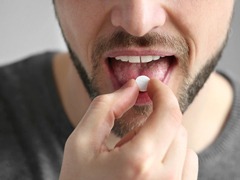 Man taking a pill to alleviate discomfort