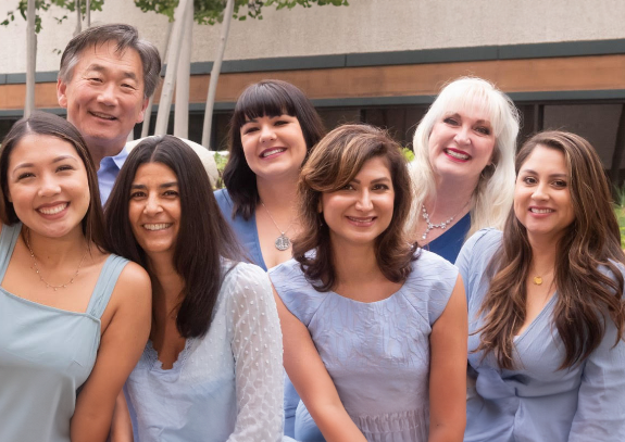 Blue Coast Dental Group team smiling in front of dental office