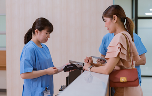 Woman checking in at dental office front desk