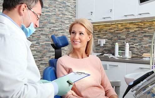 Woman in dental chair listening to her dentist