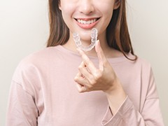 Woman putting in a single aligner for Invisalign in Torrance, CA