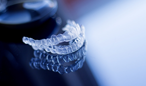 Two Invisalign trays against gray background