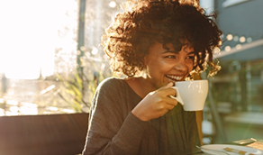 Woman drinking coffee from a white mug