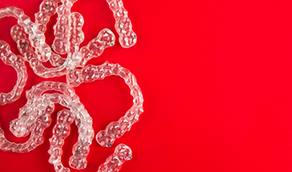 Several clear aligners against red background