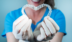Dentist holding two Invisalign aligners in the shape of a heart