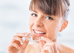 Woman placing Invisalign tray